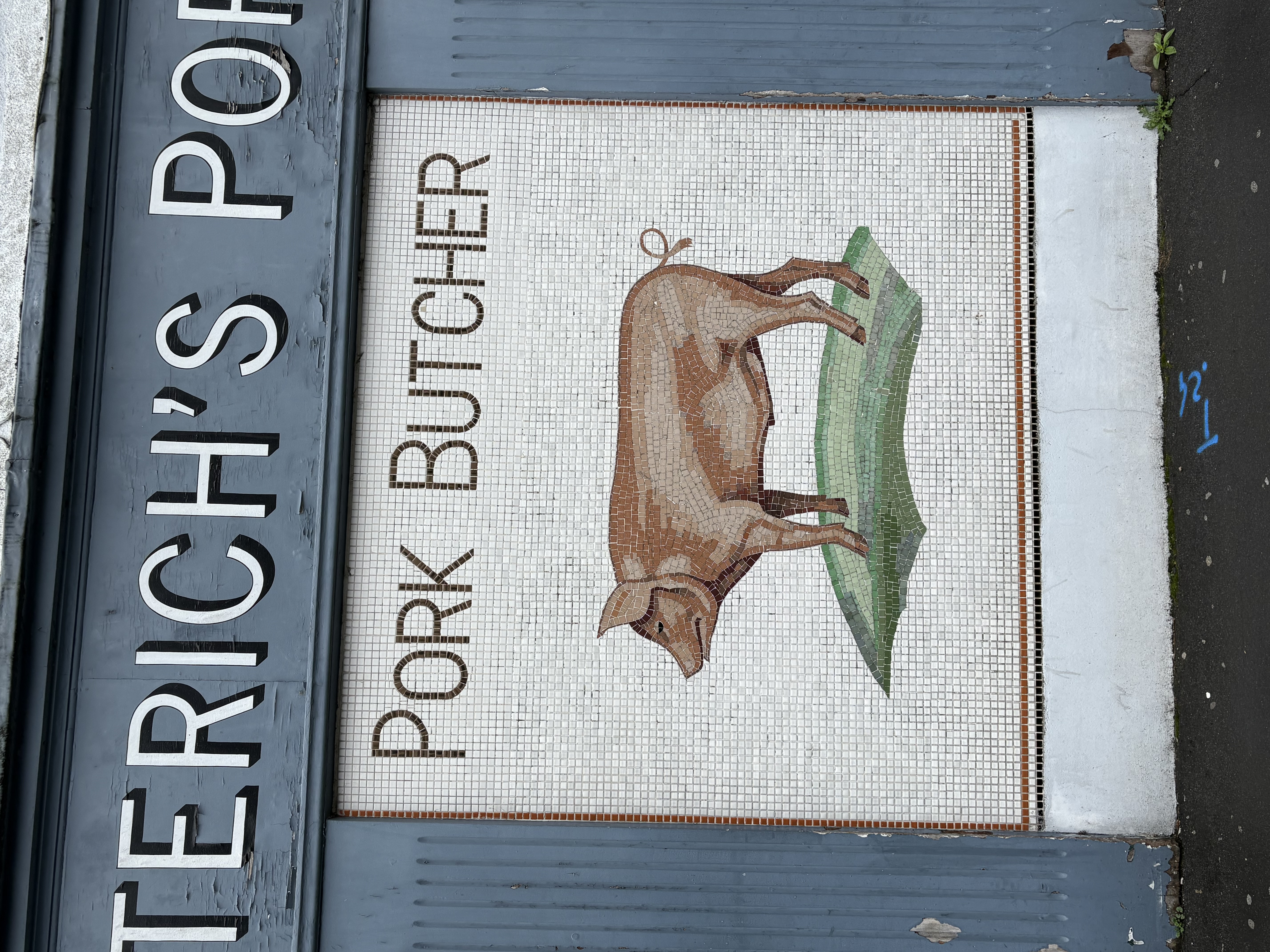 A pork butcher's mosaic shopfront sign